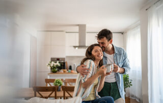 Happy homebuyers standing in a modern StreetSide Calgary townhome after learning about the First-Time Home Buyer GST Rebate.