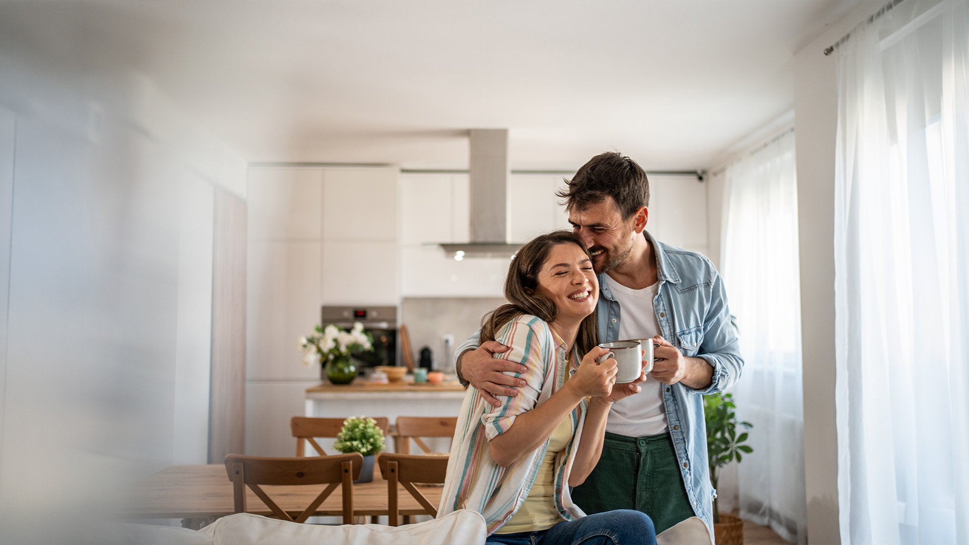 Happy homebuyers standing in a modern StreetSide Calgary townhome after learning about the First-Time Home Buyer GST Rebate.