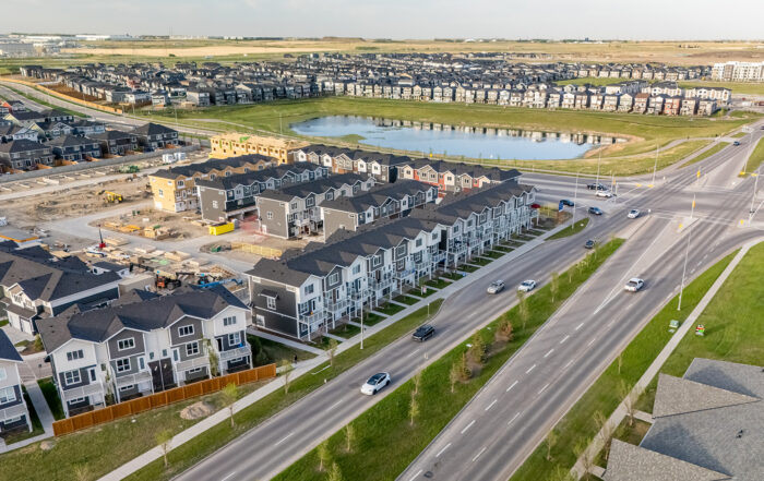 Aerial view of StreetSide townhomes in Redstone showcasing the community, with a scenic pond and naturalized green space located across the street.