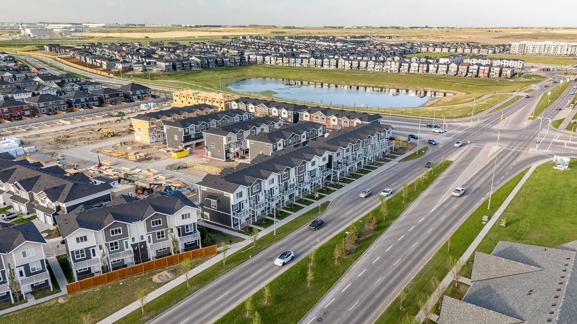 Aerial view of StreetSide townhomes in Redstone showcasing the community, with a scenic pond and naturalized green space located across the street.