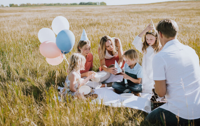 Family celebrating a birthday party among the tall prairie grasses of Vantage Rise, enjoying the community's open landscapes and natural surroundings.